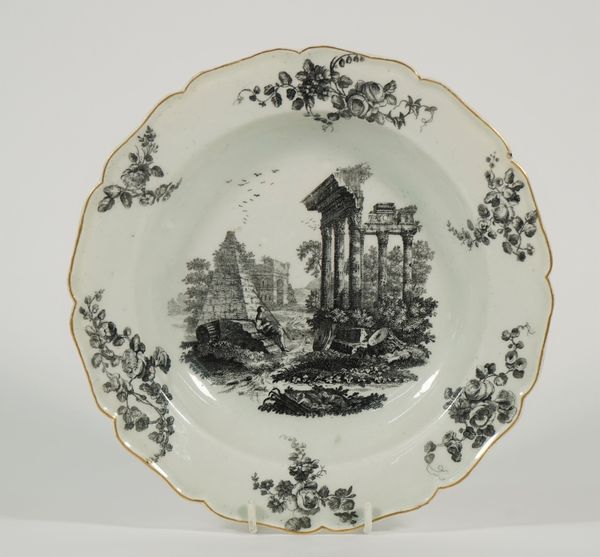 A Worcester porcelain deep plate, circa 1770, transfer printed in black with St Paul's Gate and the Temple of Jupiter, the border with six spaced flow