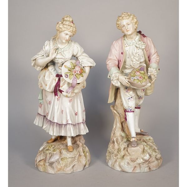 A pair of Volkstedt figures, late 19th century, modelled as a gallant and companion on a naturalistic rocky base, blue printed mark, 40cm high, (2).