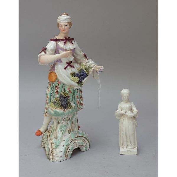 A Berlin porcelain figure of a young woman, 19th century, possibly representing Autumn, standing with grapes on a scroll moulded base, blue sceptre ma