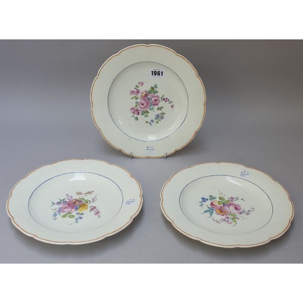 Three Chantilly porcelain plates, second half 18th century, painted with a central group of flowers and fruit inside a basket moulded border, hunting