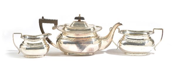 A silver three piece tea set, comprising; a teapot having black fittings, a twin handled sugar bowl and a milk jug, each piece of shaped oval form, de