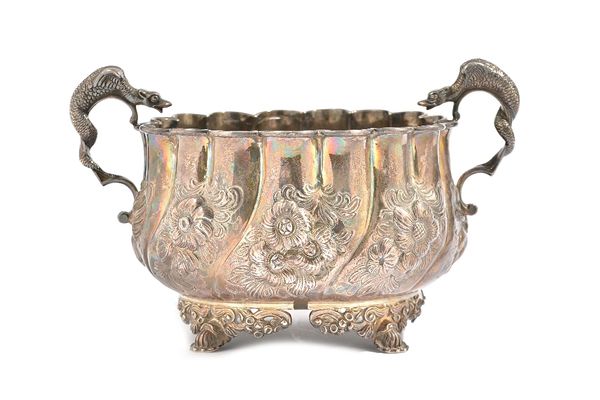 A silver twin handled bowl, the body with spiral fluted, floral, foliate and scroll embossed decoration, raised on four cast and pierced feet, the han