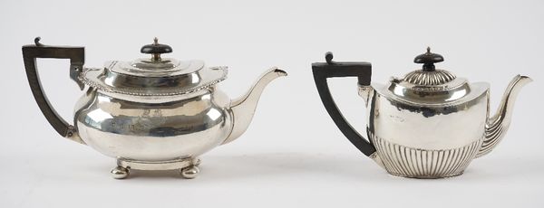 Silver, comprising; a teapot of boat shaped form, the gadrooned rim with foliate motifs to the corners, crest and motto engraved, raised on four bun f