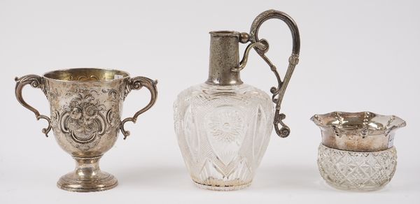 An Irish silver twin handled cup, with later floral and scroll embossed decoration, a silver rimmed, faceted glass vase, Birmingham 1907 and a Victori