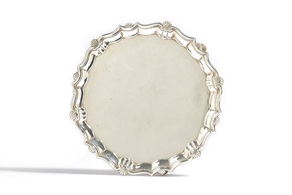 A George II silver salver, of shaped circular form, decorated with a shell and pie-crust rim, raised on three pad feet, diameter 22.5cm, London 1746,