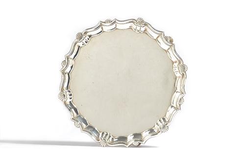 A George II silver salver, of shaped circular form, decorated with a shell and pie-crust rim, raised on three pad feet, diameter 22.5cm, London 1746,