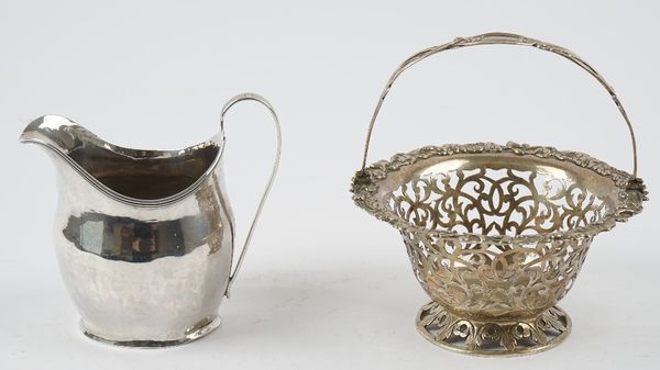 A George III silver helmet shaped cream jug, London 1803 and a Victorian silver basket, of shaped circular form, with pierced decoration, the rim with