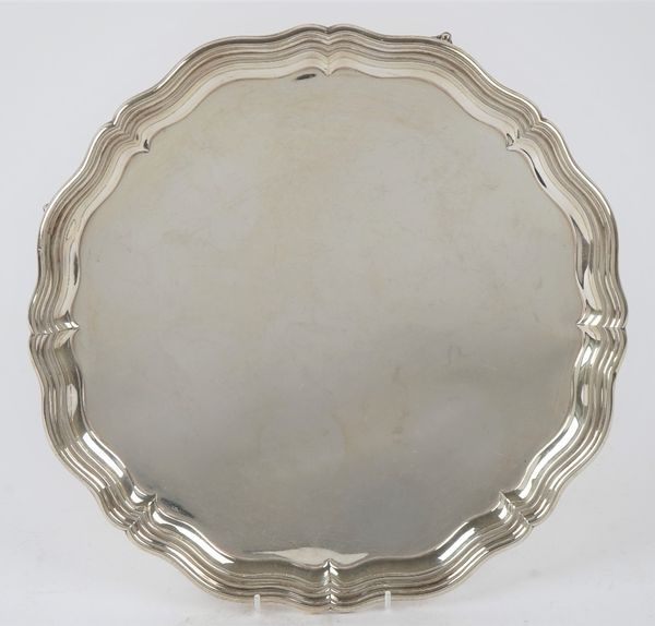 A silver salver, of shaped circular form, in the Chippendale style, raised on four ball and claw feet, diameter 36cm, Sheffield 1922, weight 1185 gms.