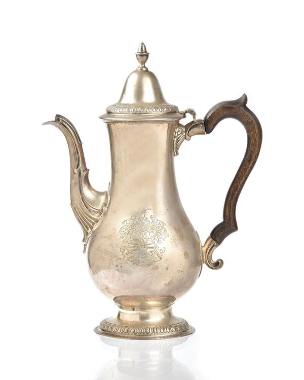 A George III silver coffee pot, of baluster form, the hinged lid and the footrim decorated with a curved gadrooned band, Newcastle 1783, the body late