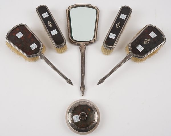 A silver mounted tortoiseshell part dressing set, comprising; a hand mirror, two hairbrushes and two clothes brushes, by Mappin & Webb, London 1930 an