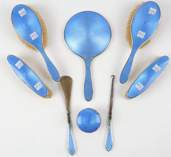 A lady's silver and blue enamelled part dressing set, comprising; a hand mirror, two hair brushes, two clothes brushes, a button hook, a shoe horn and