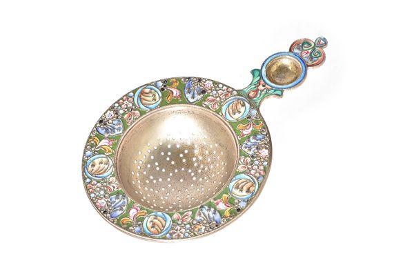 A Russian cloisonne enamelled tea strainer, the wide circular border decorated with foliate and floral motifs in a variety of colours, detailed 84, le