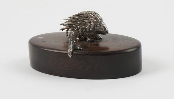 A Patrick Mavros place name or menu stand, modelled as a porcupine on an oval wooden stand, length 6cm.