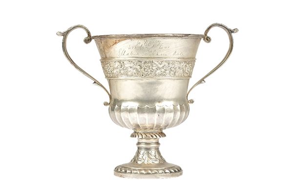 A silver twin handled large cup, of stylized campana form, decorated with fruiting vine to the band, above a partly fluted lower section, presentation