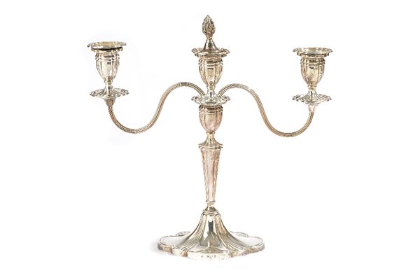 A silver three light table candelabra, the central stem raised on a shaped oval base, the detachable top section with reeded arms, height 29.5cm, Birm