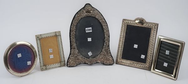 A silver mounted shaped oval photograph frame, with floral and scroll embossed decoration, detailed 925, a silver mounted shaped rectangular photograp