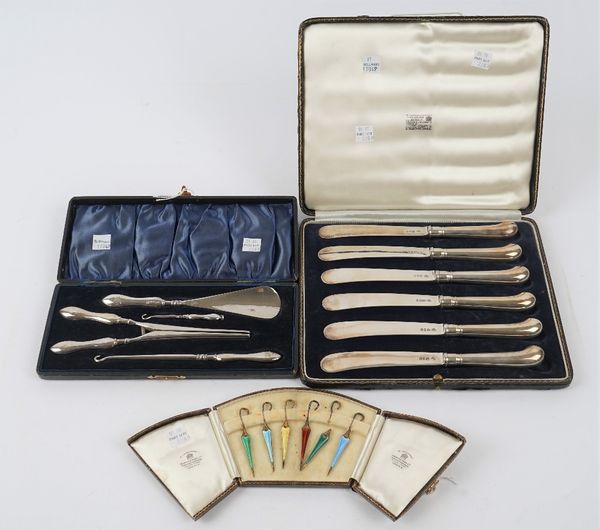 Six silver gilt and varicoloured enamelled cocktail sticks, designed as ladies umbrellas, five Birmingham 1932 and one Birmingham 1931, with a Mappin