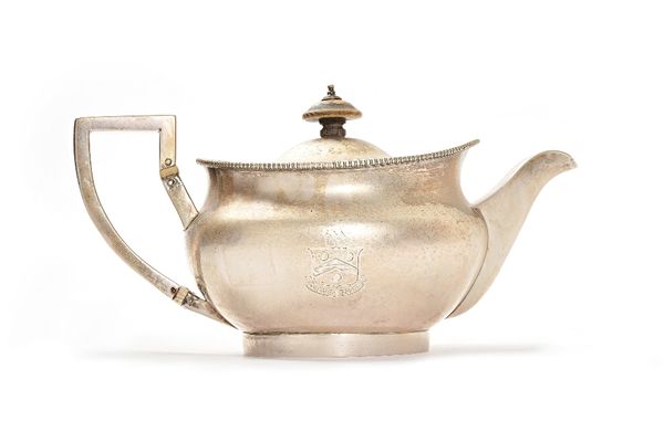 A George III silver teapot, of compressed spherical form, having a decorated rim, an angular handle and with a pull-off lid, the body engraved with a