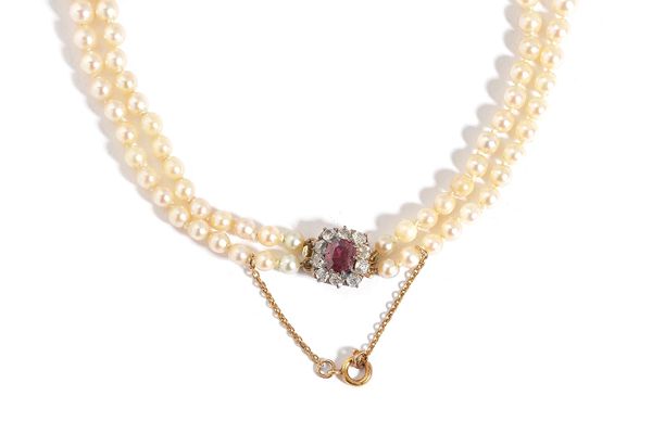 A two row necklace of graduated cultured pearls, on a gold, ruby and diamond set cluster clasp, fitted with a safety chain, with a case. Illustrated.