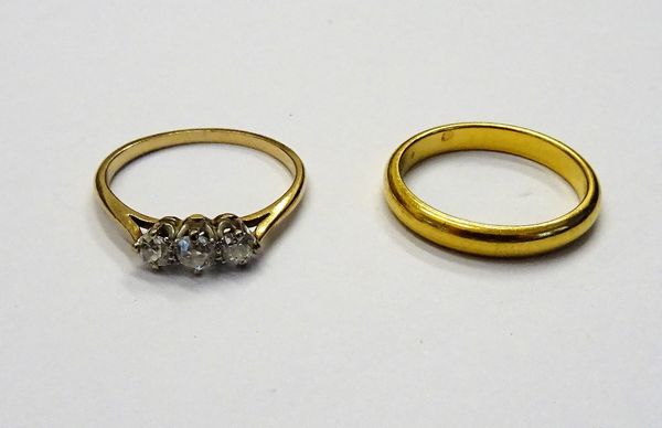 A 22 ct gold plain wedding ring Birmingham 1935, ring size M 1/2, weight 4.1 grams and a gold and diamond three stone ring, claw set with a row of cus