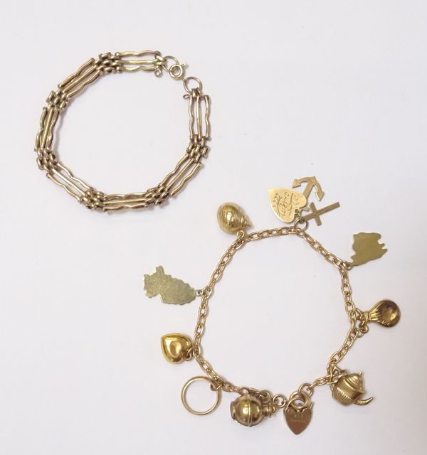 A 9ct gold oval link charm bracelet, with a 9ct gold heart shaped padlock and a boltring clasp, fitted with nine mostly 9ct gold charms, but including