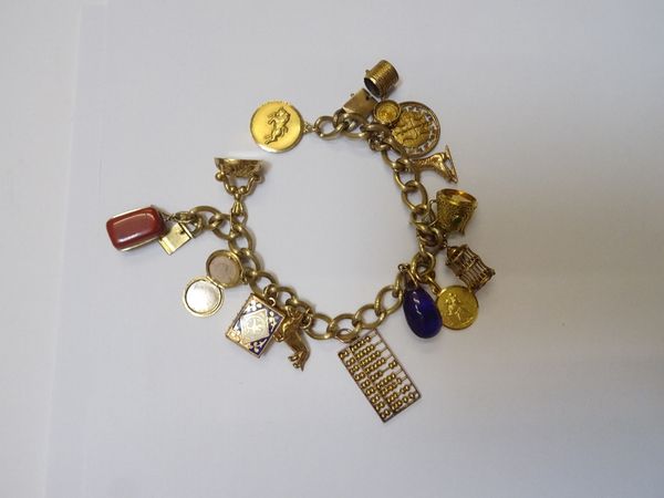 A gold decorated curb link charm bracelet, on a snap clasp, detailed 14 K, fitted with fourteen various gold and other charms, including, Taurus, a do