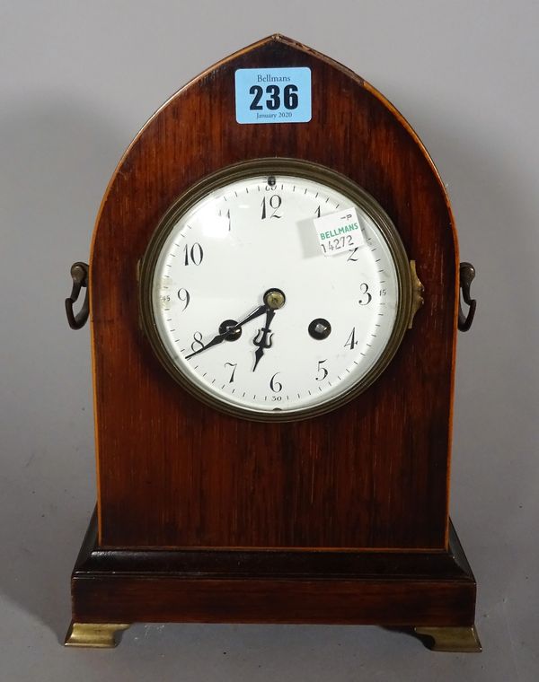 An early 20th century mahogany cased clock of lancet form on brass bracket feet, 16cm wide x 27cm high.  D3