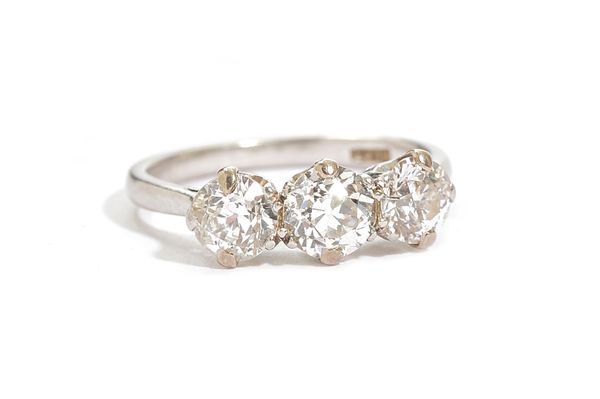 A platinum and diamond set three stone ring, claw set with a row of cushion shaped diamonds, detailed PLAT, ring size O, gross weight 4.7 gms. Illustr