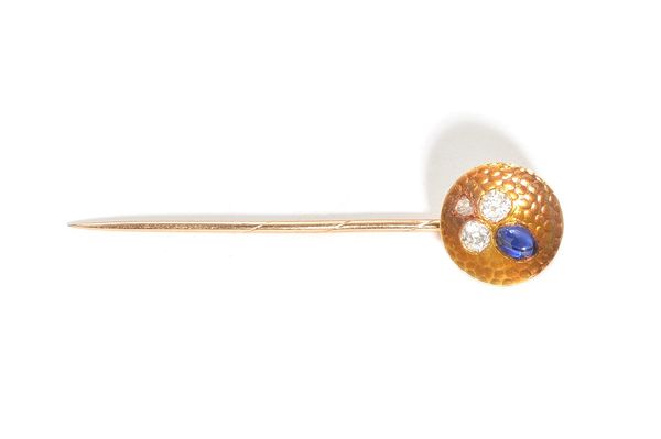 A gold, diamond and sapphire set stick pin, the dished circular top with a trefoil shaped motif, mounted with two cushion shaped diamonds, a rose cut