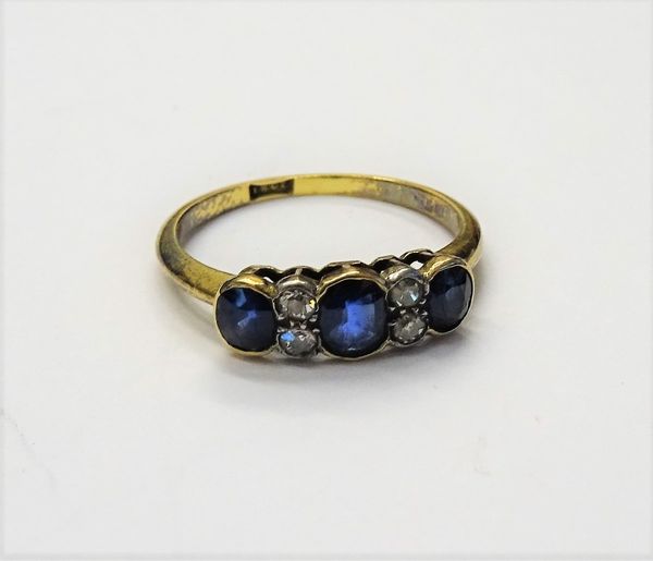 A gold, sapphire and diamond ring, mounted with three oval cut sapphires and with two pairs of cushion shaped diamonds mounted at intervals, detailed