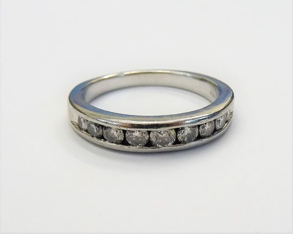 A platinum and diamond half hoop eternity ring, channel set with a row of nine circular cut diamonds, ring size K and a half, gross weight 5 gms.