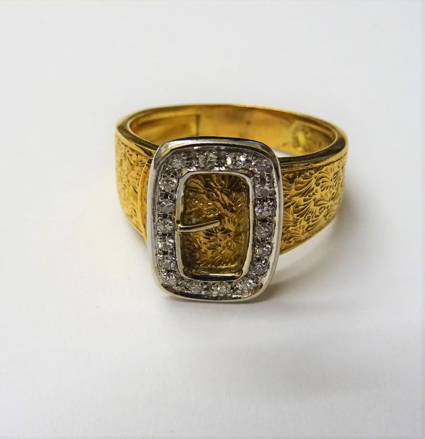 A gold and diamond set ring, with a buckle motif, mounted with circular cut diamonds, otherwise with engraved decoration, detailed 18 CT, ring size R