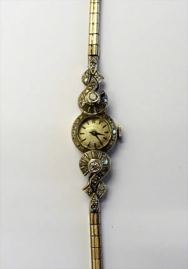 A lady's diamond set white precious metal cocktail watch, the small guilloche circular dial, with baton markers, and eight cut diamonds to the bezel,