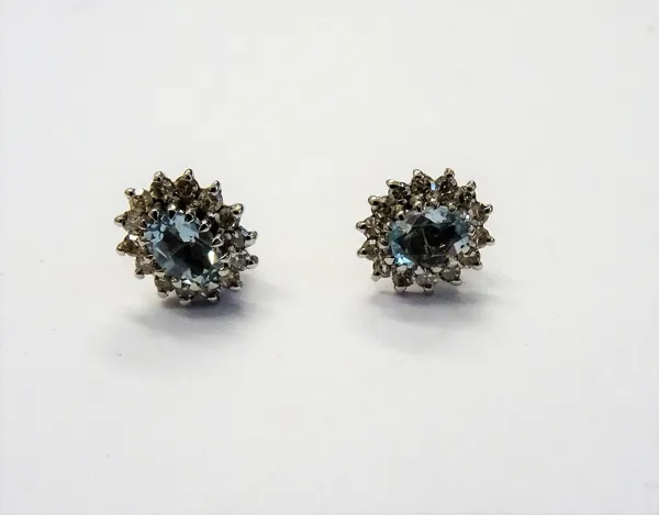 A pair of 9ct white gold, aquamarine and diamond set oval cluster earstuds, each claw set with an oval cut aquamarine in a surround of circular cut di
