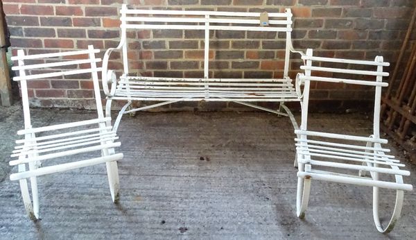 An early 20th century white painted metal slatted garden bench, 112cm wide x 76cm high and two matching chairs, 44cm wide x 70cm high, (3).  OUT