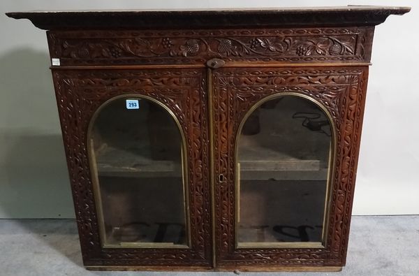 An early 20th century rosewood display cabinet with arch panelled glass doors and carved decoration, 94cm wide x 74cm high. C5