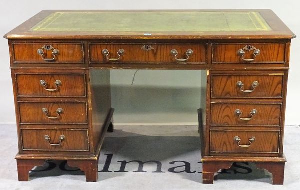 A 20th century hardwood pedestal desk with nine drawers about the knee, 138cm wide x 77cm high and a similar two drawer filing cabinet, 64cm wide x 79