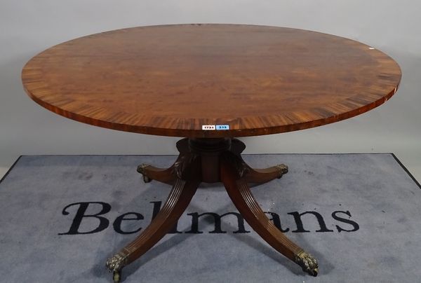 A George III coromandel banded mahogany centre table, the circular snap top on turned column and four downswept supports, 130cm diameter x 74cm high.