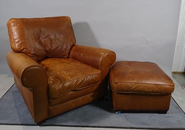 A 20th century hardwood framed low armchair with tan leather upholstery, 105cm wide x 80cm high and a matching footstool, 57cm wide x 40cm high, (2).