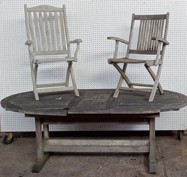 A 20th century teak oval garden table, 206cm long x 111cm wide and a set of nine associated teak folding chairs, four painted grey, (10).  OUT