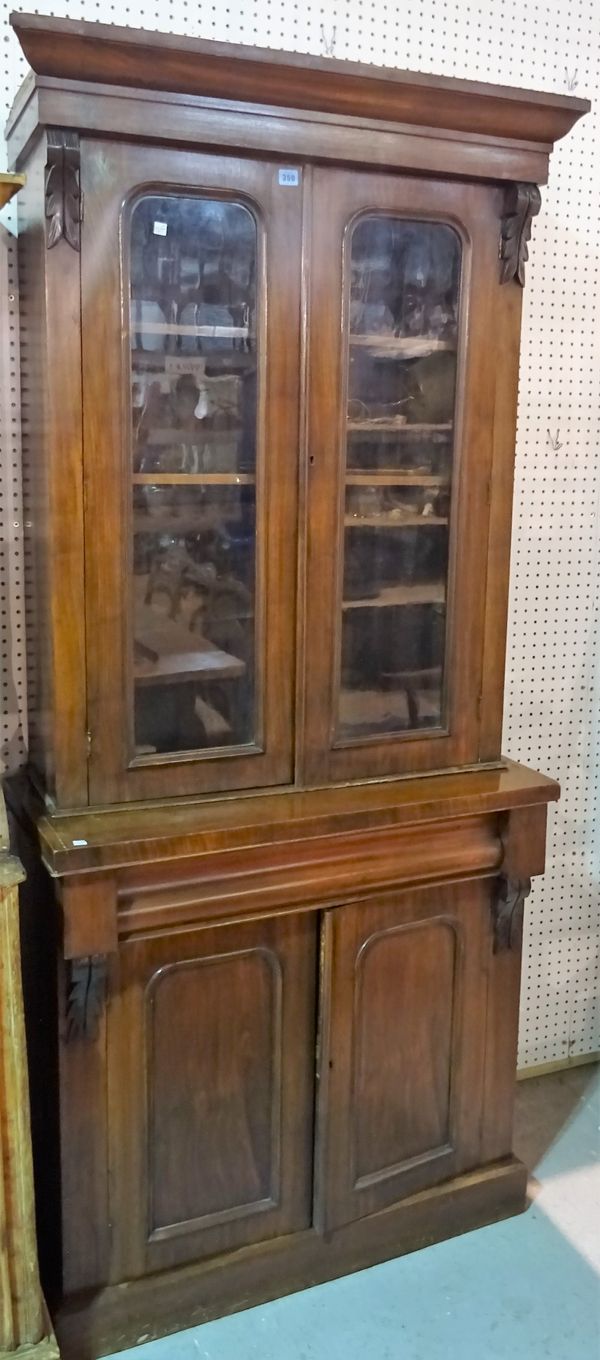 A Victorian walnut bookcase cabinet with moulded arch glazed doors on plinth base, 115cm wide x 198cm high. B5