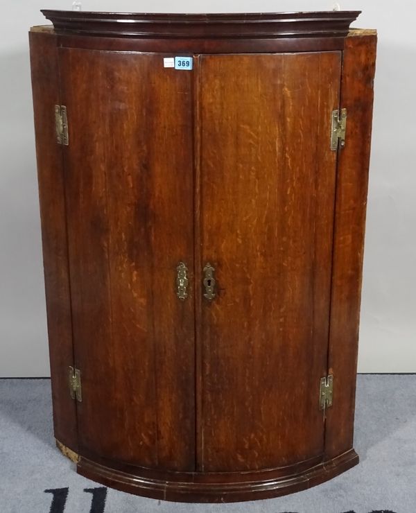 A mid-18th century oak bowfront hanging corner cupboard, 75cm wide x 102cm high.  D3