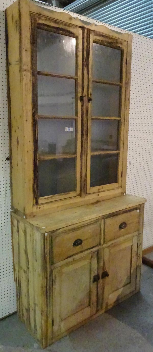 An early 20th century pine dresser with two door glazed top section over two drawer cupboard base, 107cm wide x 233cm high.  A1