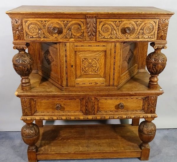 A 17th century style oak side cupboard with carved decoration on baluster turned supports, 104cm wide x 120cm high.  A2