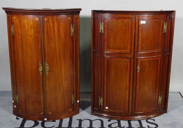 A late George III inlaid mahogany bowfront hanging corner cupboard, 62cm wide x 102cm and another similar, 72cm wide x 99cm high, (2). B3