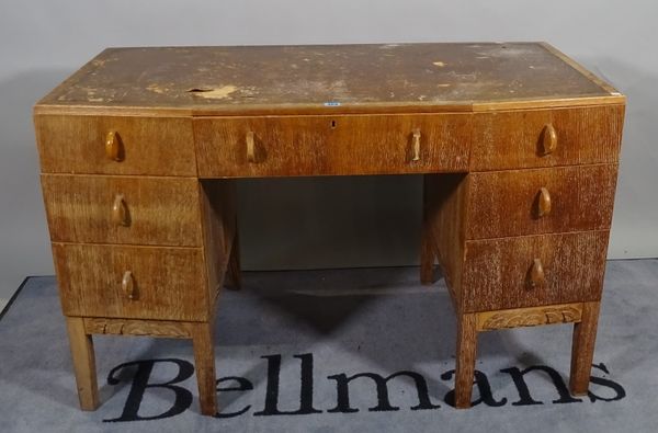 A mid-20th century lined oak kneehole desk with nine drawers about the knee on block supports, 121cm wide x 76cm high.  D4