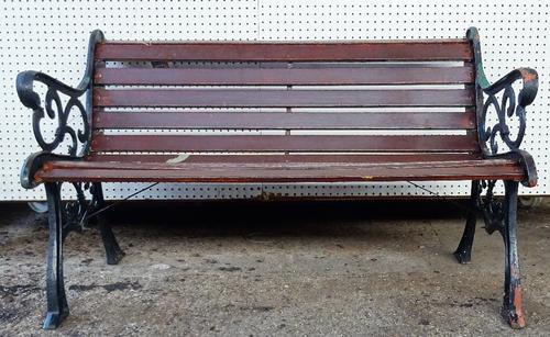 A 20th century black painted cast iron garden bench with scroll ends and wooden slats, 128cm wide x 78cm high.   OUT