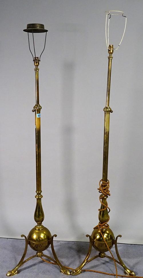A pair of early 20th century brass standard lamps with outswept supports, 150cm high, (2). D1