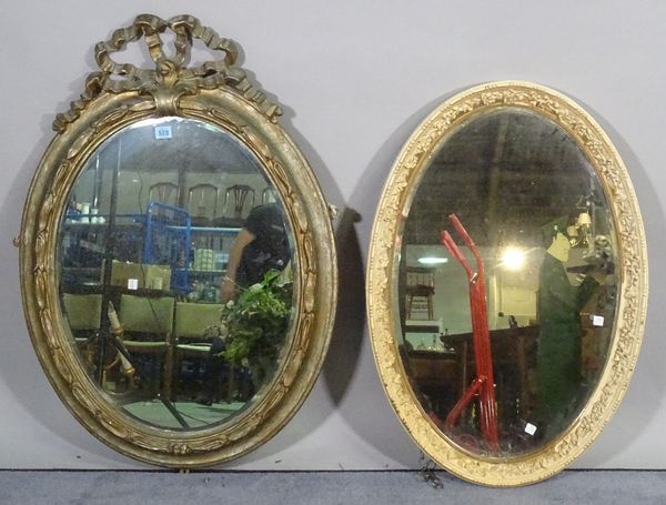 A Regency style giltwood oval wall mirror with ribbon tied crest, 68cm wide x 90cm high and another later painted oval mirror, 59cm wide x 82cm high,