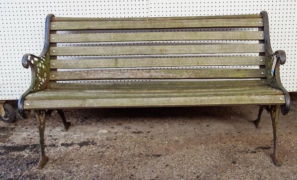 A late Victorian cast iron wooden slatted garden bench with scroll ends, 139cm wide x 78cm high.  OUT